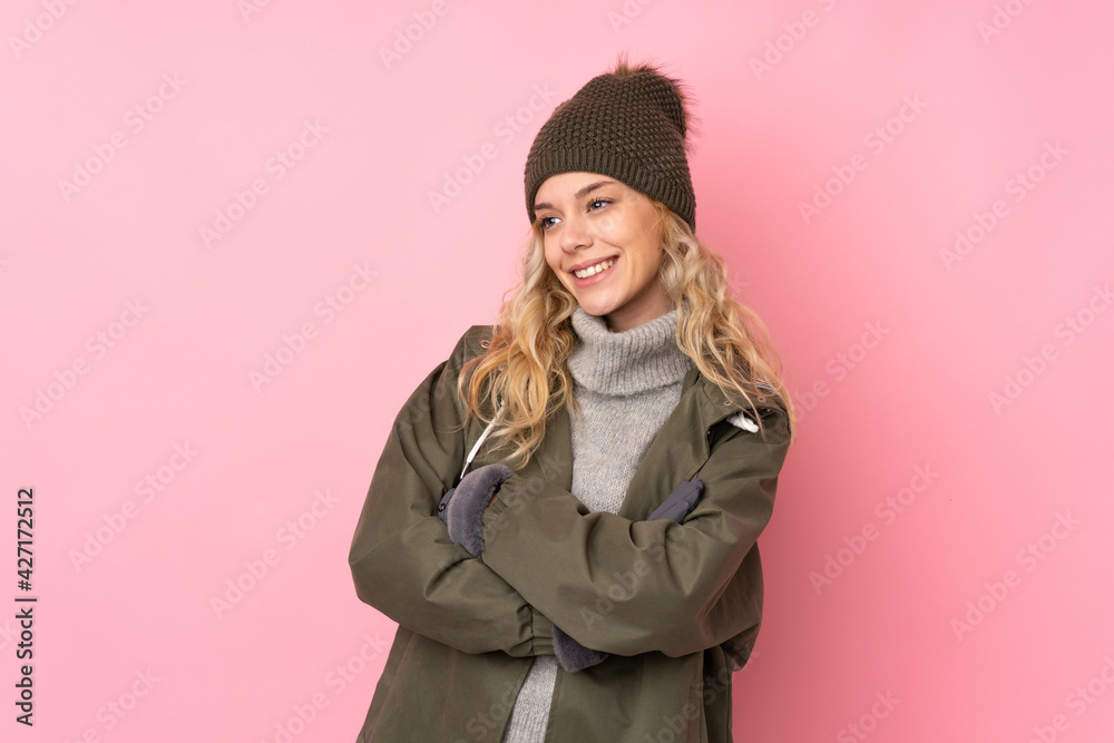 Young girl with winter hat isolated on pink background looking to the side Young girl with winter hat isolated on pink background looking to the side