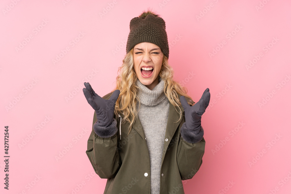 Young girl with winter hat isolated on pink background unhappy and frustrated with something Young girl with winter hat isolated on pink background unhappy and frustrated with something
