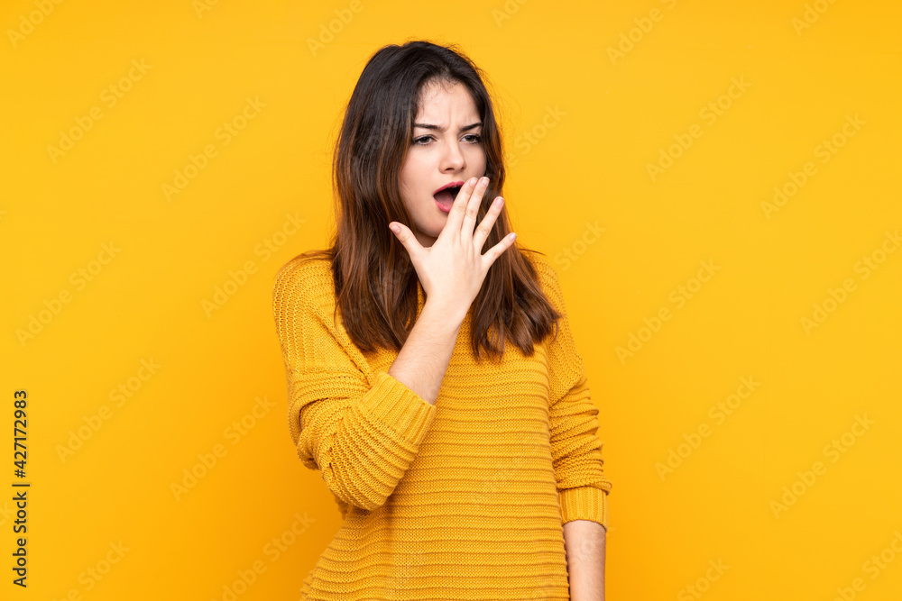 Young caucasian woman isolated on yellow background yawning and covering wide open mouth with hand Young caucasian woman isolated on yellow background yawning and covering wide open mouth with hand