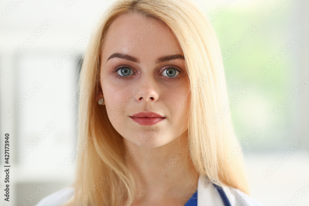 Beautiful smiling female doctor stand in office portrait