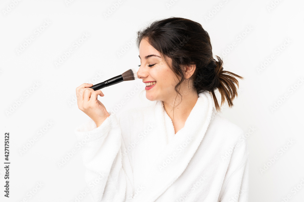 Young caucasian woman isolated on white background holding makeup brush and whit happy expression Young caucasian woman isolated on white background holding makeup brush and whit happy expression