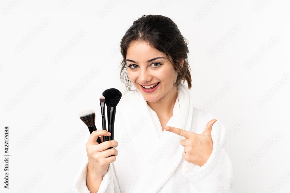 Young caucasian woman isolated on white background holding makeup brush and pointing it Young caucasian woman isolated on white background holding makeup brush and pointing it