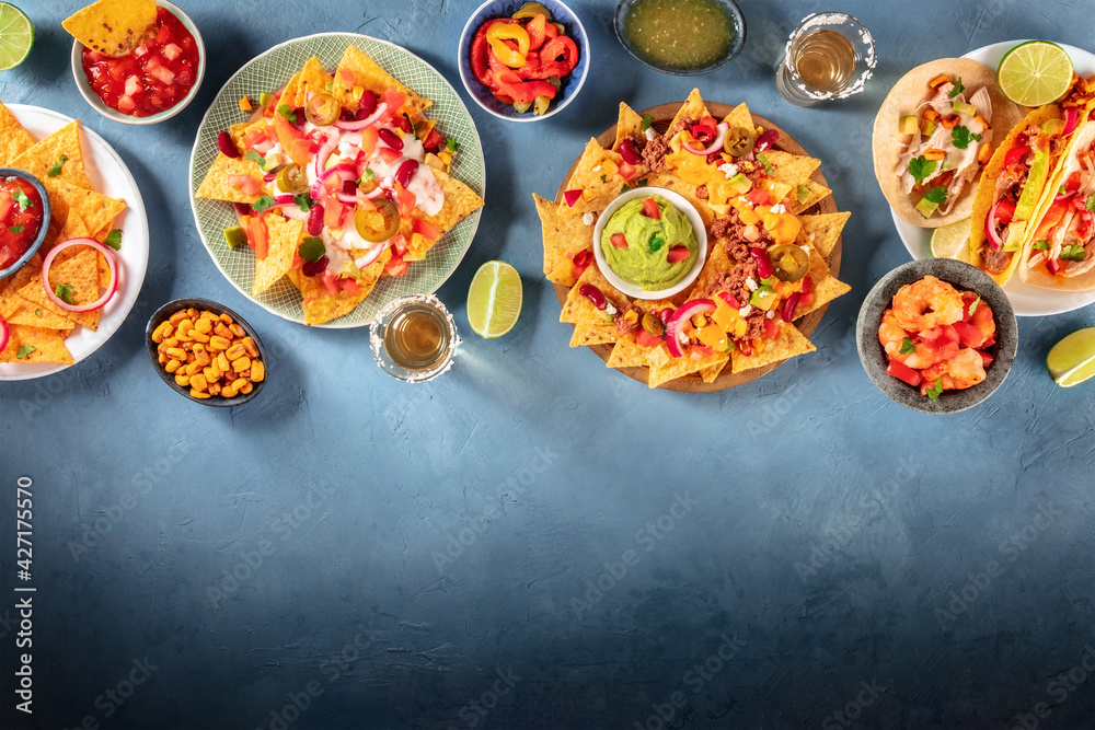 Nachos, tequila, tacos and other Mexican dishes, shot from above