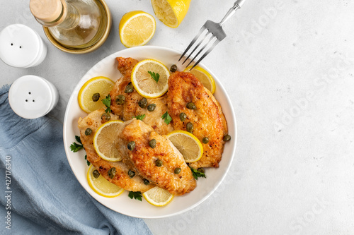 Konstfotografi Chicken piccata on white table directly above