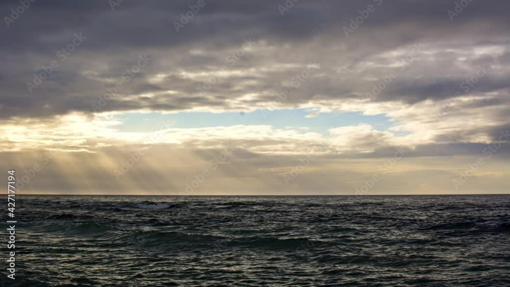 Cloudy ocean sunset over wavy ocean, time lapse Cloudy ocean sunset over wavy ocean, time lapse