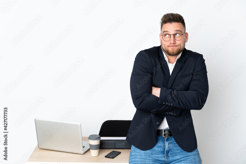 Russian man in a office isolated on white background making doubts gesture while lifting the shoulders Russian man in a office isolated on white background making doubts gesture while lifting the shoulders