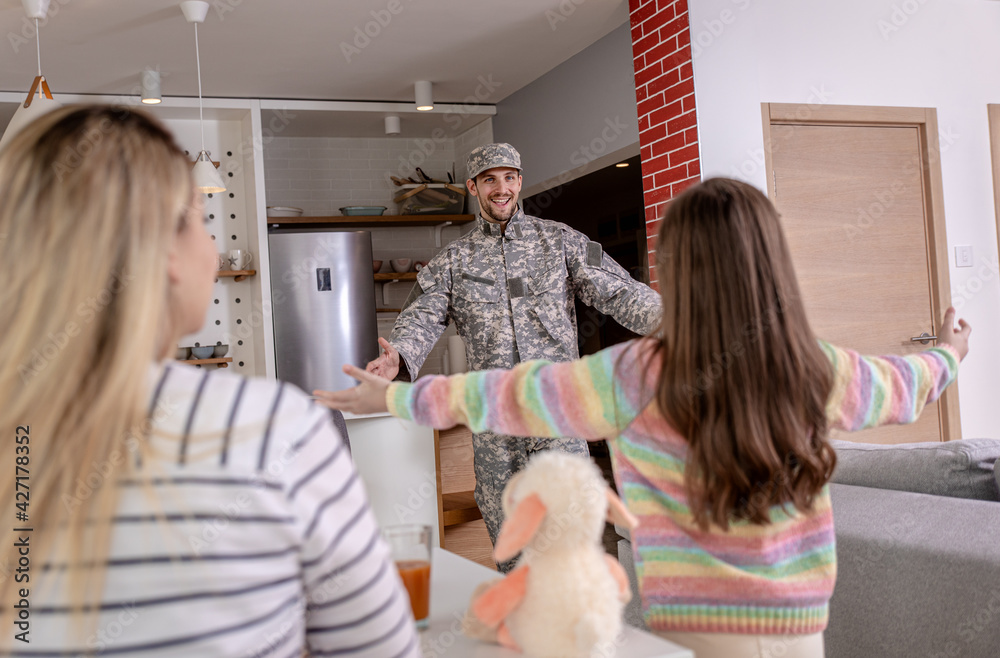 Soldier surprised his family by coming home, the daughter runs towards him to hug him.