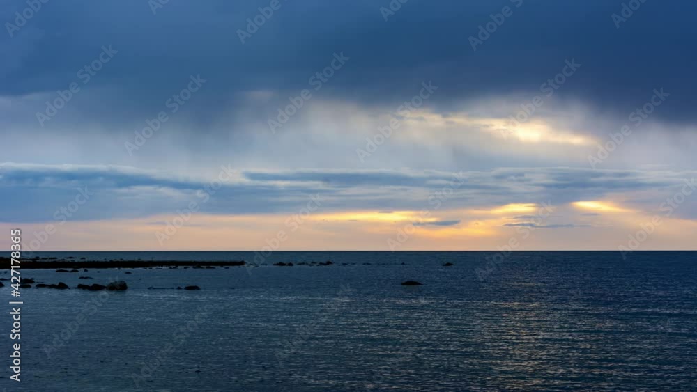 Clouds passing over the sky and ocean in time lapse at sundown Clouds passing over the sky and ocean in time lapse at sundown