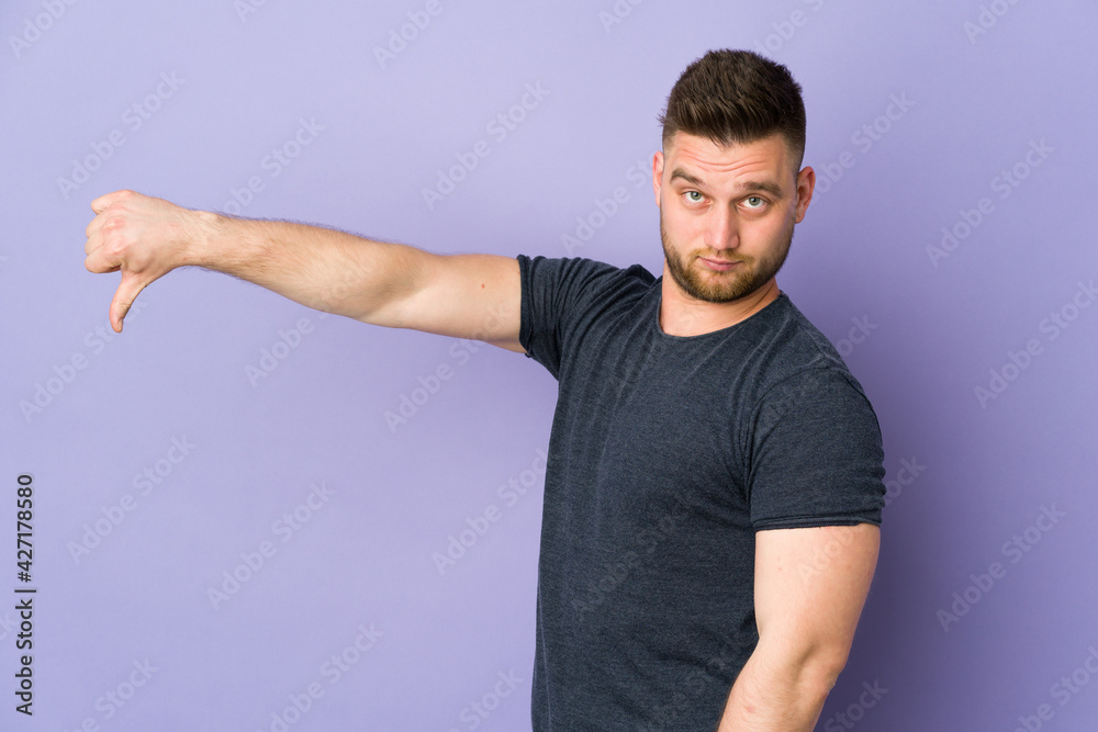 Russian handsome man over isolated background showing thumb down with negative expression