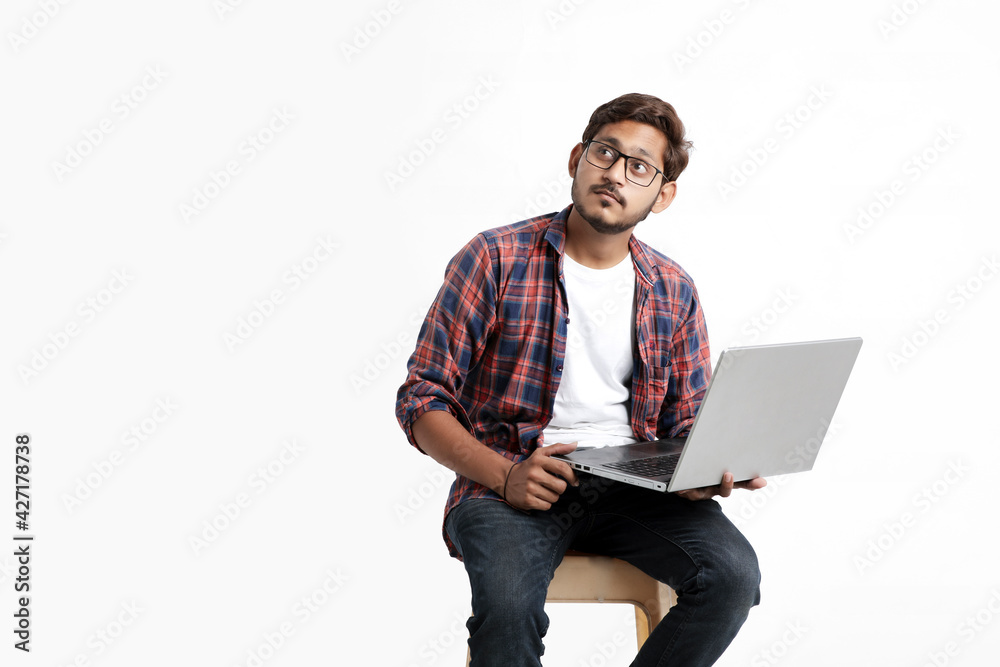 Young indian man thinking some idea when working on laptop.