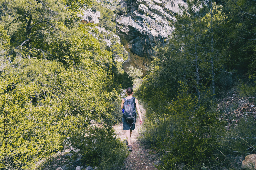 Naklejka premium woman hiking on a mountain path in catalonia