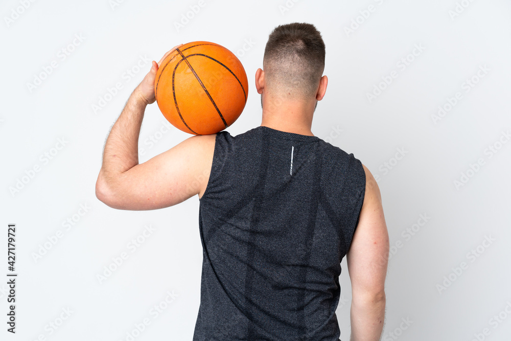 Russian handsome man isolated on white background playing basketball in back position