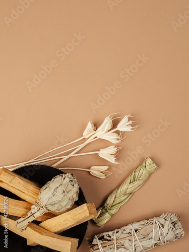 Set of incense for fumigation. Tied in a bunch of sprigs of white sage, sweetgrass, dried flowers, Palo Santo sticks. View from above. Organic holy tree incense from Latin America.