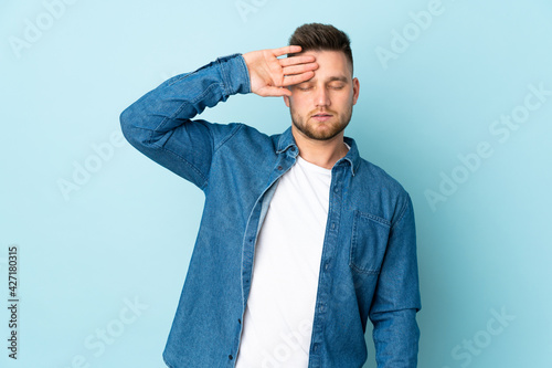 Russian handsome man isolated on blue background with tired and sick expression