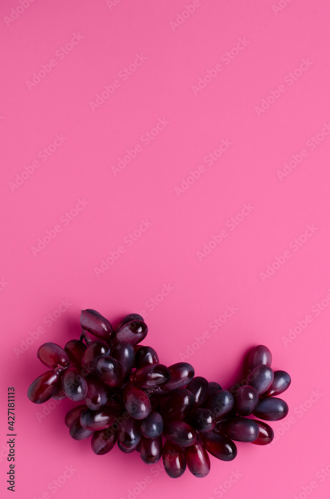 Top view of empy glasswine, corckscrew and red grapes on the pink surface.Empty space Top view of empy glasswine, corckscrew and red grapes on the pink surface.Empty space