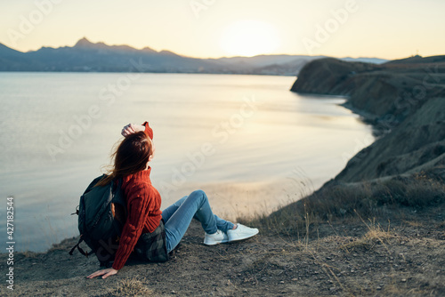 a traveler with a backpack on the sand relaxes in nature near the sea in the mountains