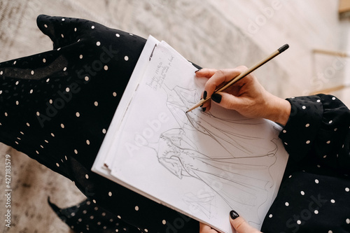 Valokuva Closeup of a fashion wedding designer sketching new bridal dresses with a pencil