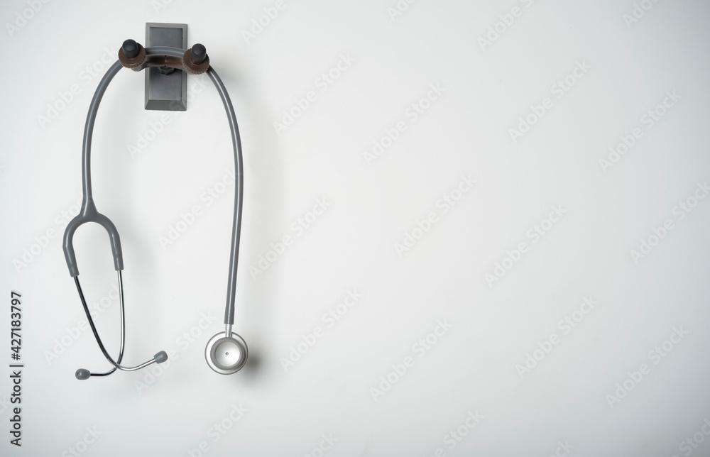 stethoscope equipment of doctor with is hanging on the white wall background stethoscope equipment of doctor with is hanging on the white wall background