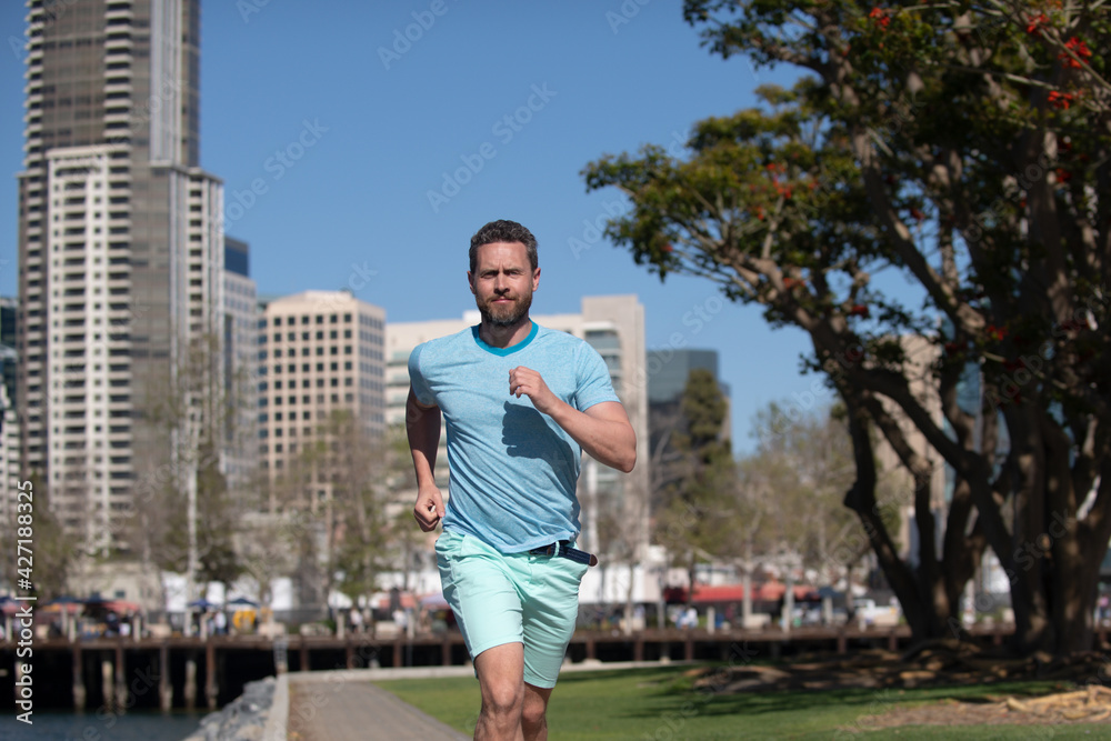 Man runner jogger running in the city on a beautiful summer day.