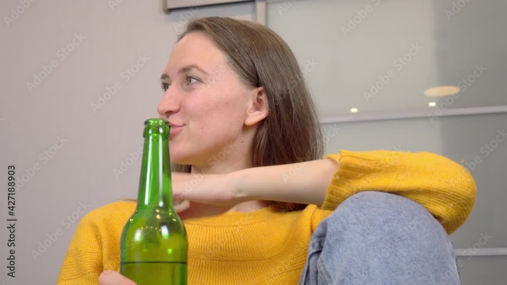 Two beautiful attractive girls, friends or sisters, drink beer and eat delicious pizza, at home in their kitchen. They talk and laugh. Blonde and brunette. Two beautiful attractive girls, friends or sisters, drink beer and eat delicious pizza, at home in their kitchen. They talk and laugh. Blonde and brunette.