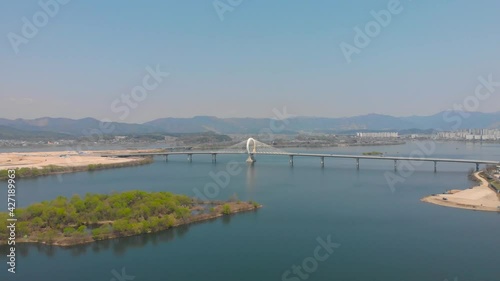 The Circle shaped bridge is cross the huge river lake. water is calm and mountains lay down back. The drone aerial footage took with 4K 30fps. The landmark or architecture.