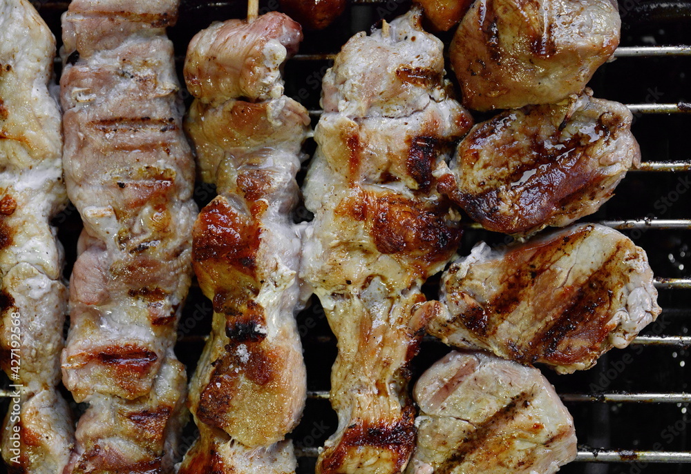 Assorted delicious grilled meat over the coals on a barbecue.