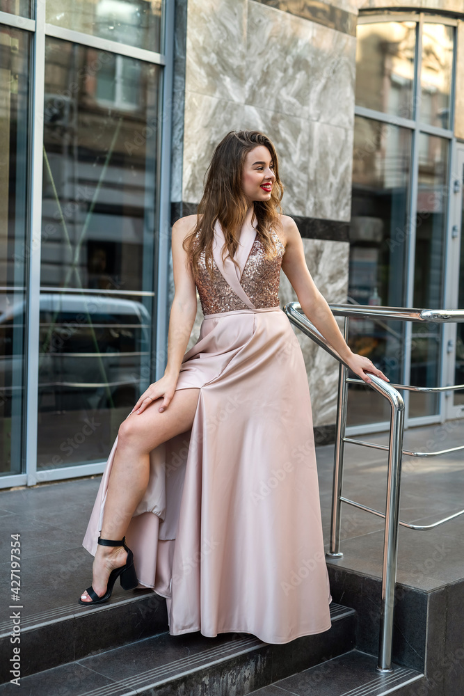 Fashion full-length portrait pretty lady in attractive ball gown dress at city street Fashion full-length portrait pretty lady in attractive ball gown dress at city street