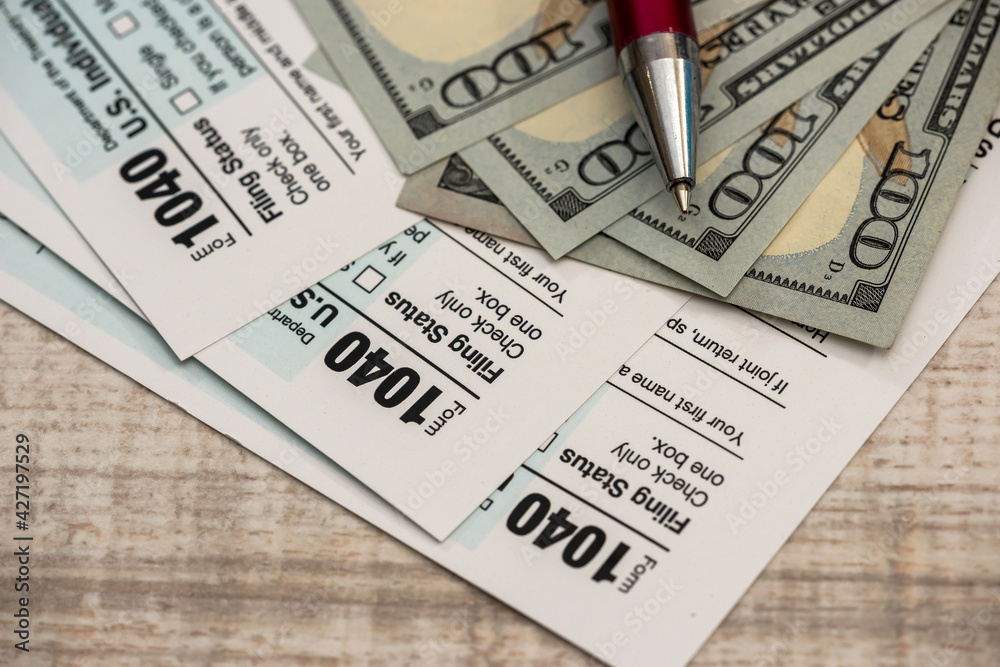 Obraz premium pen and dollar bills and US 1040 tax form