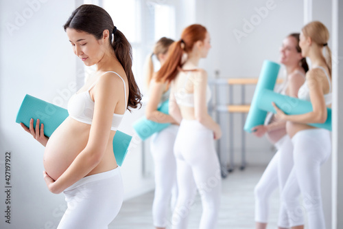 portrait of asian pregnant woman with big tummy posing at camera