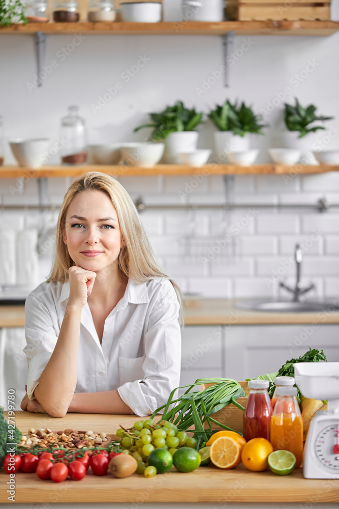 blonde pleasant woman of european appearance like healthy eating, stand by table with fresh food blonde pleasant woman of european appearance like healthy eating, stand by table with fresh food