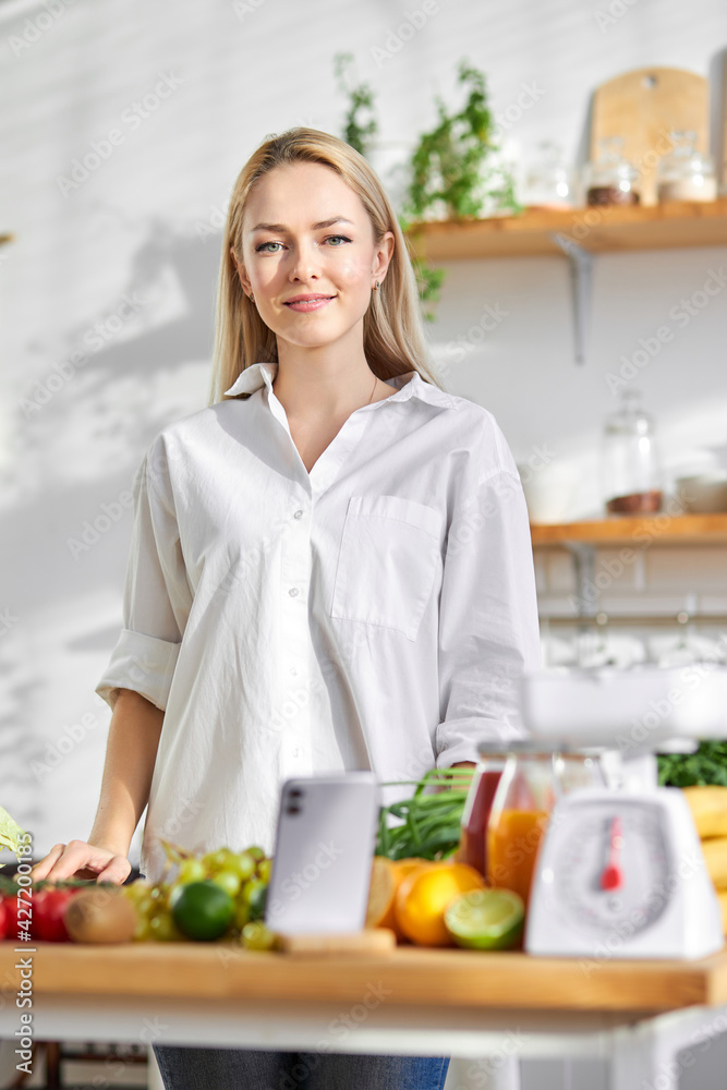 female is engaged in process of preparing food in kitchen from fresh vegetables