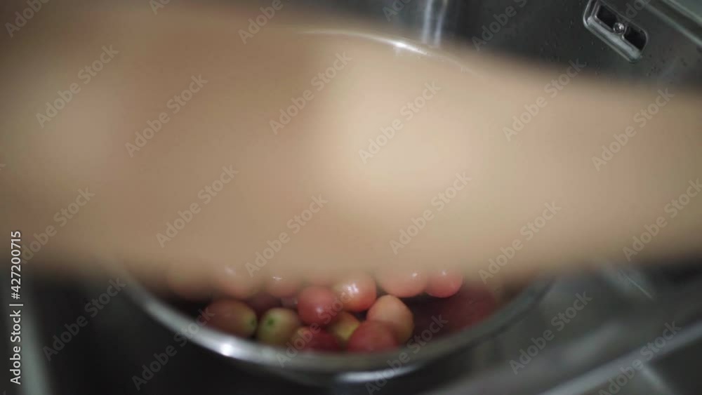 close-up video of woman washing fresh tomatoes in washing sink preparation for cooking salad in kitchen at home