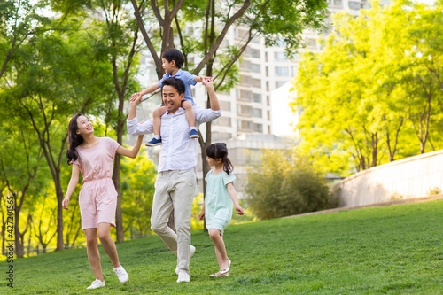 Happy young family playing in park photo