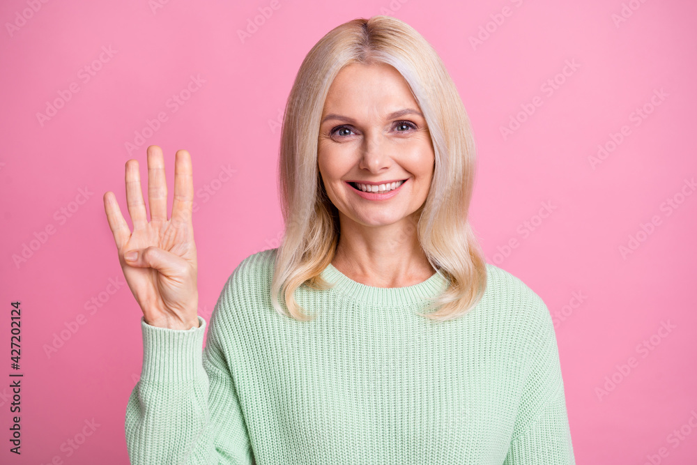 Photo of pretty cute mature woman dressed green pullover smiling counting fingers four isolated pink color background Photo of pretty cute mature woman dressed green pullover smiling counting fingers four isolated pink color background
