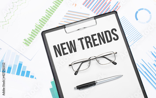 new trends sign. Conceptual background with chart ,papers, pen and glasses