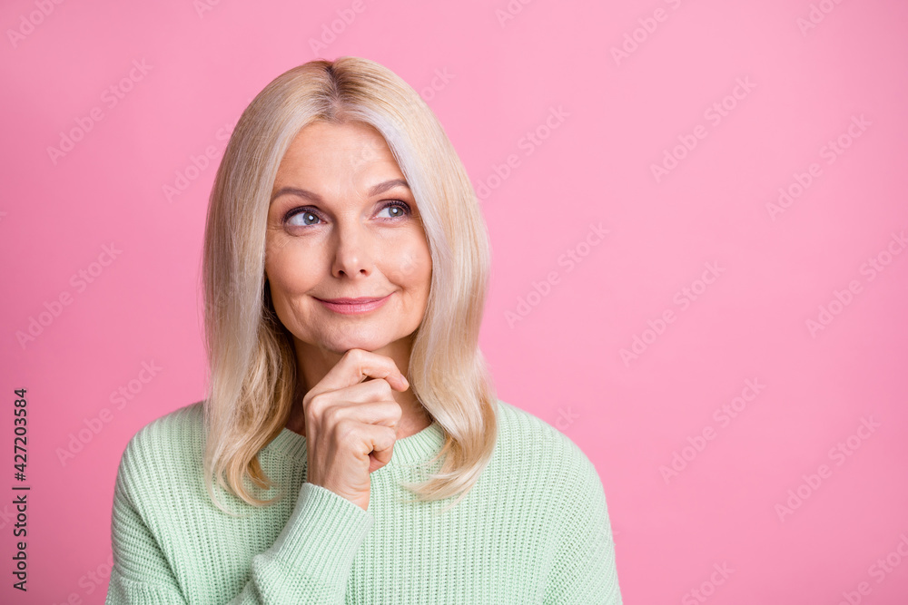 Photo portrait of thoughtful old lady looking at blank space isolated on pastel pink colored background Photo portrait of thoughtful old lady looking at blank space isolated on pastel pink colored background