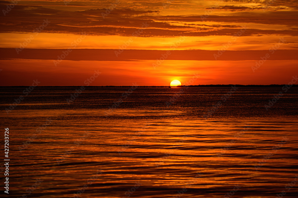 Sunrise sun over skyline horizon. Natural sunset over ocean. Dramatic sky. Seascape.