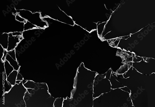 Cracked broken glass on a white background. Damaged window texture. Cracks on a black background.