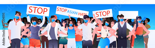 stop asian hate people in masks holding banners against racism support during coronavirus pandemic concept