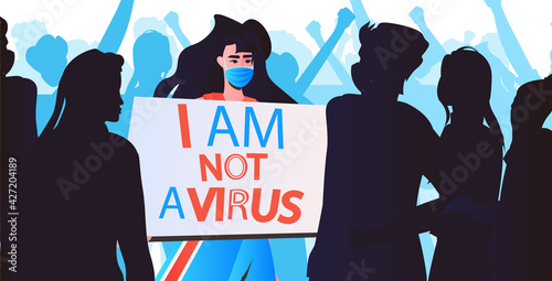 stop asian hate woman in mask holding banner against racism support people during coronavirus pandemic