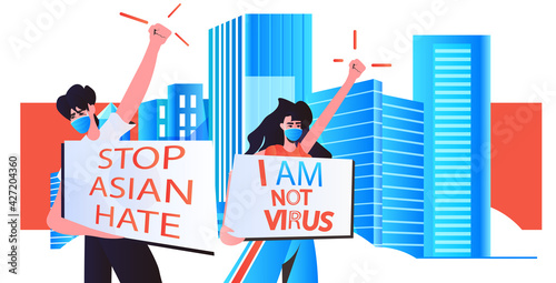 stop asian hate couple in masks holding banners against racism support people during coronavirus pandemic