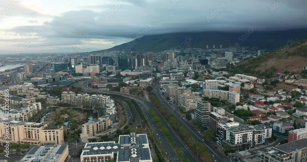 Wide aerial shot tracking forward into the city of Cape Town during a spectacular sunset with Table Mountain in the background. Wide aerial shot tracking forward into the city of Cape Town during a spectacular sunset with Table Mountain in the background.