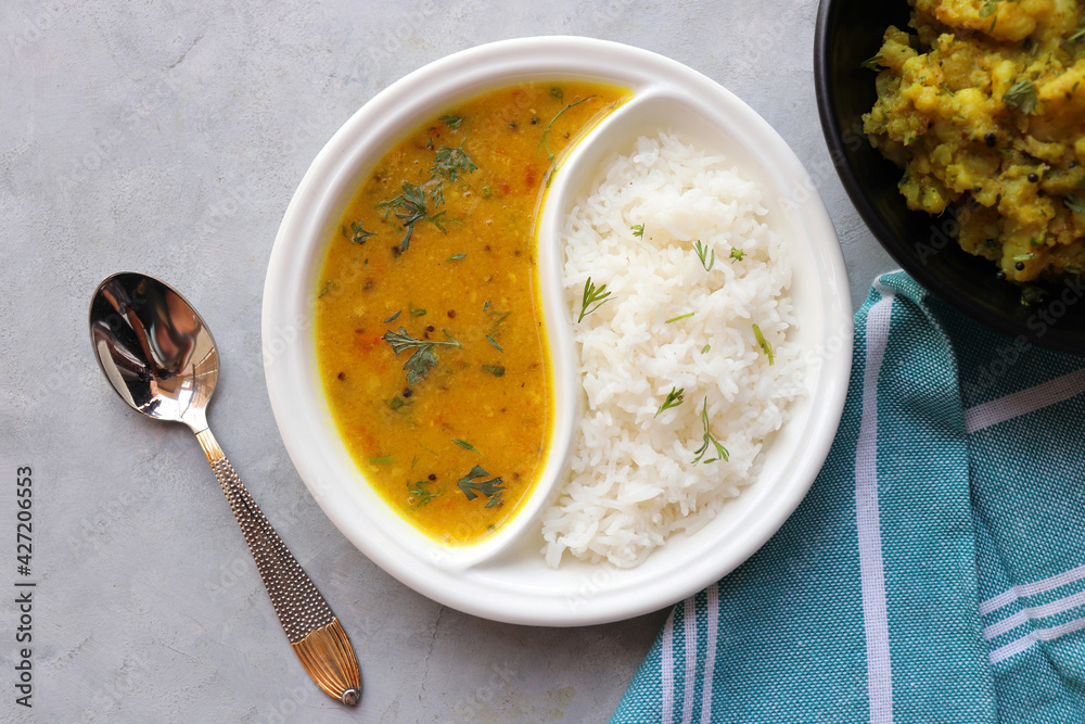 Healthy nutritious Indian comfort food Dal Chawal thali or Dal Rice, also  commonly known as Varan bhat in Marathi. Served in two way ceramic plate.  Over white background with copy space. foto