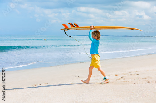 Canvas Print Happy surf boy - young surfer learn to ride on surfboard with fun on sea waves