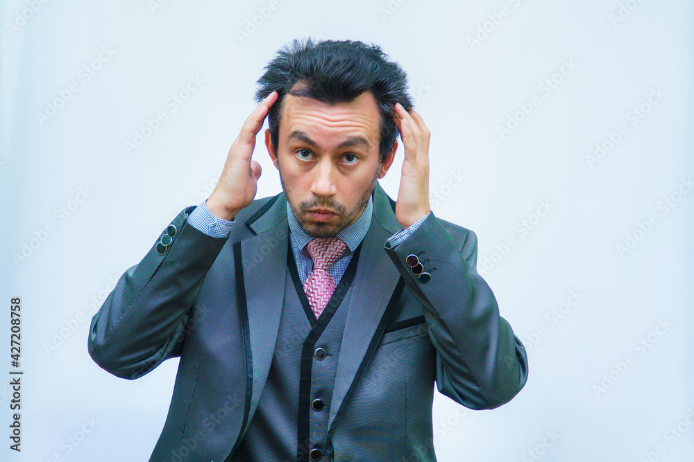 A man with tousled hair in a business suit straightens his hair A man with tousled hair in a business suit straightens his hair