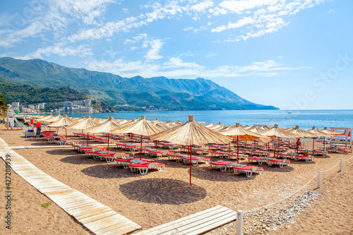 Quadro su tela Becici beach in Montenegro , Sun umbrellas and loungers at the sandy beach