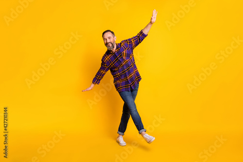 Full size photo of funky charming mature man hands wings weekend enjoy isolated on yellow color background