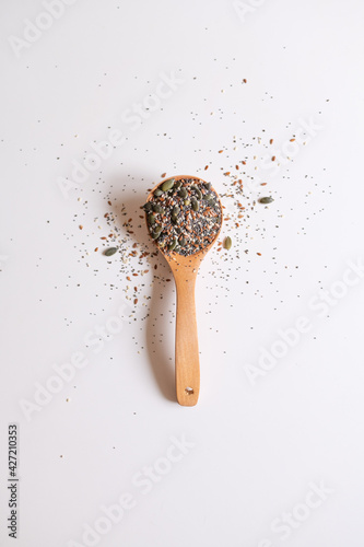 A wooden spoon with edible seeds on a white kitchen table