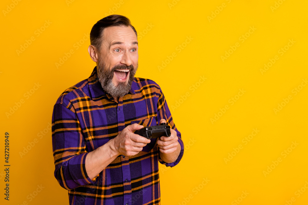 Portrait of attractive excited cheerful guy playing video game battle having fun copy space isolated over bright yellow color background Portrait of attractive excited cheerful guy playing video game battle having fun copy space isolated over bright yellow color background