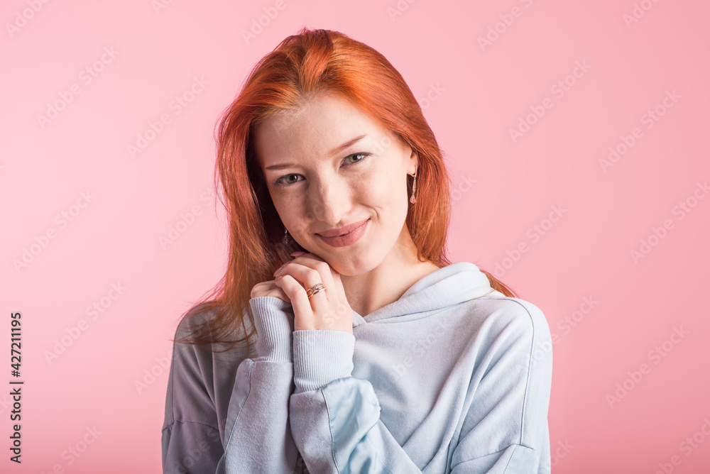 Portrait of a happy redhead girl in the studio on a pink background Portrait of a happy redhead girl in the studio on a pink background